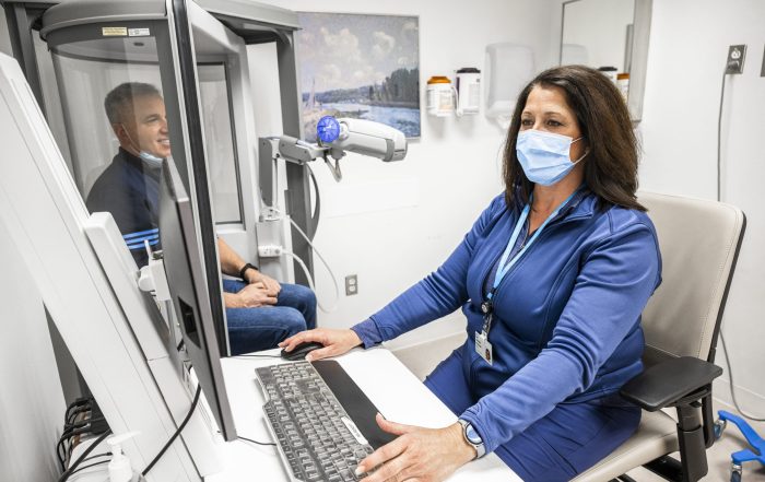 A respiratory caregiver giving a lung function test to a patient in a hospital.