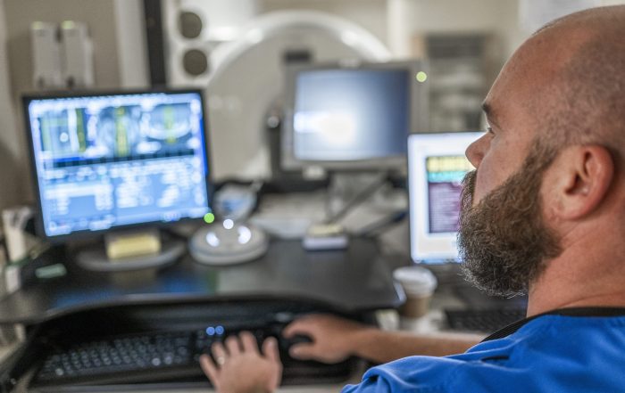 A caregiver looks at medical test results on computer screen.