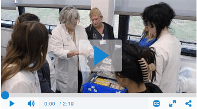 Instructor demonstrating a medical procedure to students in a classroom.