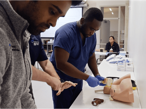 Two male students working with patient care simulation technology